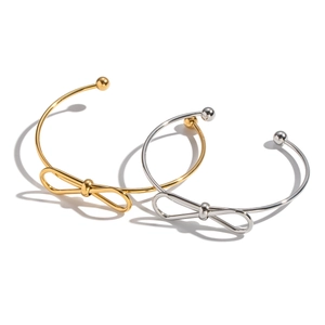 Minimalist bow open cuff bracelets in polished gold and silver finishes on white background