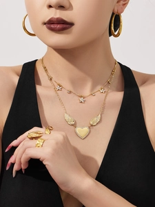 Close-up of elegant gold wing heart necklace and matching earrings set on model