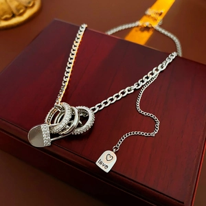 Detail of silver link necklace with crystal circles and love tag on red wood gift box