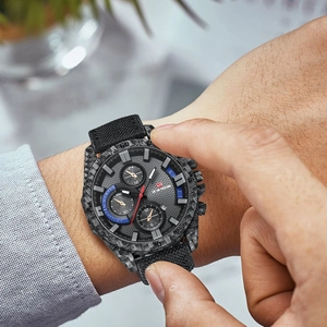 Men's waterproof sport watch with carbon fiber case and black nylon strap on wrist