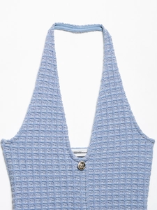 Detailed view of sky blue waffle knit halter neck dress with golden accent button