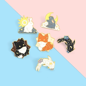 Detailed view of colorful enamel pins featuring animals and celestial motifs in gold plating
