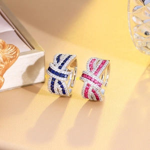Macro detail of silver rings set with blue and red gemstones and ribbon zircon stones