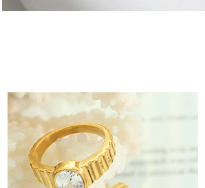 Macro shot of gold ring with oval zircon stone and vertical relief texture