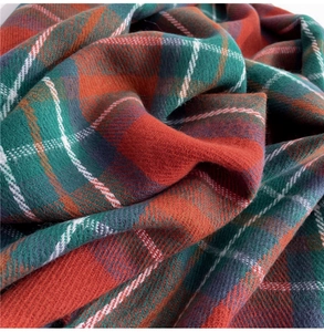 Macro shot of thick red and green plaid scarf showing soft fabric texture and weave details