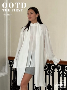 Detail of elegant white chiffon shirt with neck tie and long sleeves on model