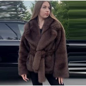 Détail d'un manteau en fausse fourrure marron avec revers larges et ceinture à nouer