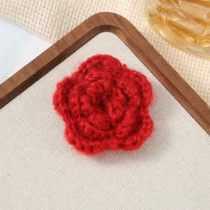 Detailed view of a handmade 7cm red crochet flower with three-layered petal texture