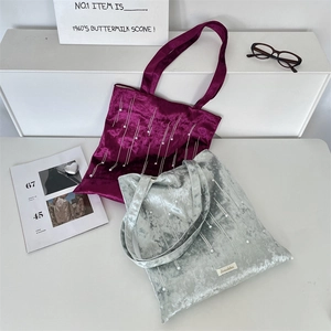 Detailed view of velvet tote bags featuring pearl embellishments and vertical stitching