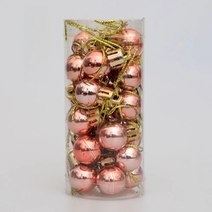 Close-up of 2cm rose gold Christmas ball ornaments with hanging strings in a clear tube