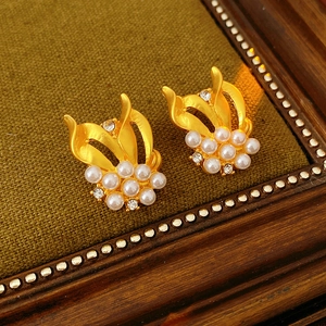 Detailed shot of vintage gold stud earrings with white pearls and clear zircons