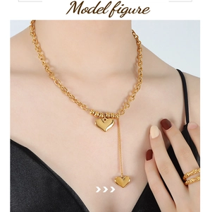 Detail shot of chunky 18K gold plated double heart pendant necklace and textured ring on model