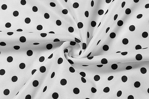 Close-up of white fabric with black polka dots and high-quality twill weaving texture