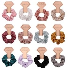 Set of 12 colorful satin hair scrunchies displayed on individual card tags in a grid