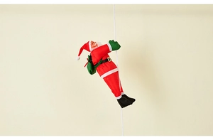 Close-up of climbing Santa Claus plush hanging on a rope ladder with red suit and green bag