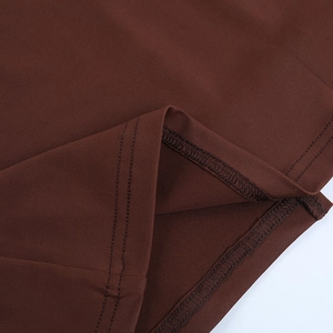 Detail view of double-needle stitching and inner overlock seam on dark brown knit fabric