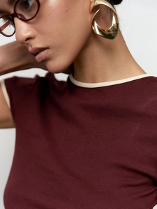 Vue détaillée du t-shirt en maille bordeaux avec col crème contrasté et boucles