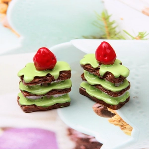 Macro view of miniature resin strawberry cakes with green icing and layered details