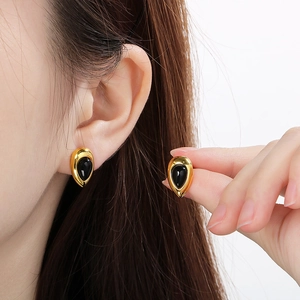Boucles d'oreilles goutte en plaqué or 18K avec opale noire portées par un mannequin