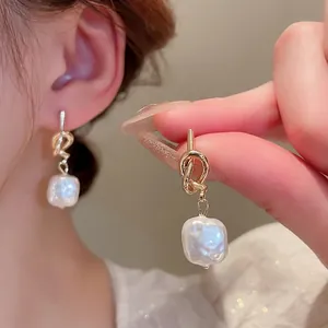 Orecchini con perle barocche e nodo metallico dorato per donne dallo stile elegante
