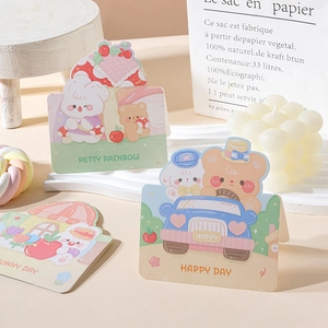 Detailed view of three cartoon animal greeting cards with pastel rabbit and bear illustrations