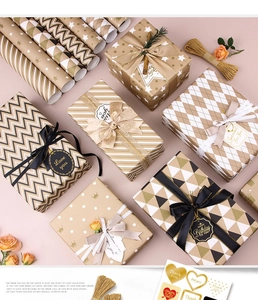 Flat lay of gold printed gift wrap set with ribbons, tags and luxury geometric patterns