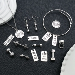 Detailed flat lay of silver gym charms with barbell pendants and fitness phrases