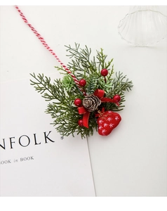 Close-up of Christmas resin branch with pine cones, red berries and festive bow ribbon