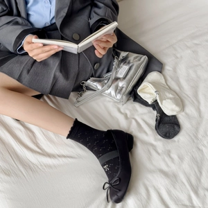Sweet cream-colored bow socks with hollow mesh design shown with black Mary Janes