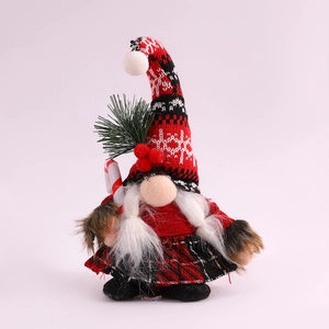 Detail of Christmas gnome with knit snowflake hat holding a red white candy cane