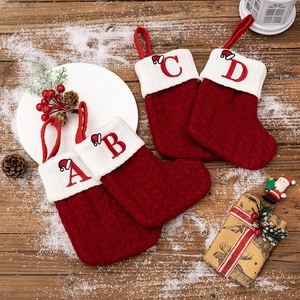 Red knit Christmas stockings with white cuffs and embroidered A, B, C, D alphabet letters
