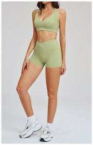 Dettaglio del reggiseno sportivo con incrocio e pantaloncini yoga a vita alta verde oliva