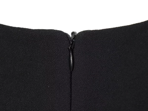 Macro shot of invisible back zipper on black crepe fabric of a short dress