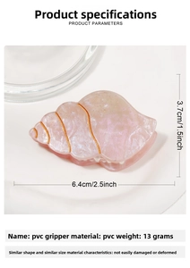 Close-up of pink shell-shaped hair claw clip with golden lines and PVC texture detail