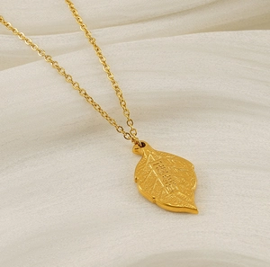 Macro shot of gold leaf pendant with Chinese character engraving on silk fabric