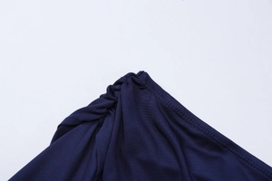 Détail macro de la robe en maille bleu foncé présentant un design d'épaule torsadée