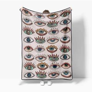 Detailed texture of bohemian printed flannel blanket held by hands in white studio