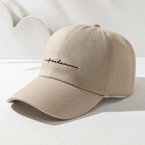 Detailed close-up of khaki cotton baseball cap with black freedom embroidery script