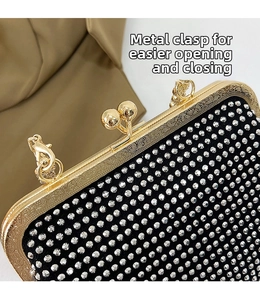Detailed view of the gold embossed metal clasp and sparkling rhinestones on the evening bag