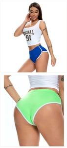 Detail von hoch taillierten Stretch-Fitness-Shorts in Blau und Lindgrün mit Paspeln