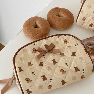 Quilted semi-circle makeup bag with brown trim and cute cartoon animal prints