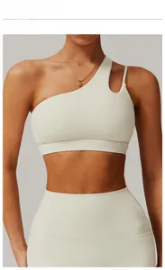 Detail of creamy apricot one-shoulder yoga bra and high waist leggings for fitness