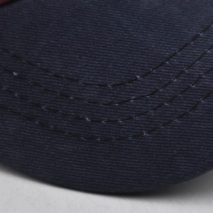 Close-up of navy blue washed baseball cap brim with reinforced stitching and twill texture