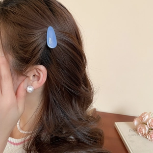 Détail d'une pince à cheveux goutte bleu Morandi avec l'inscription France Handmade et perles