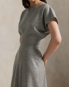 Detail of grey knitted dress featuring a cinched waist and textured fabric