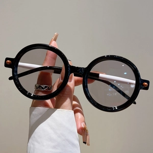 Gros plan détaillé des lunettes de soleil rondes rétro avec monture noire et branches blanches