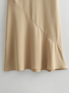 Détail du tissu de la robe gilet beige à col en V avec coutures obliques et beau drapé