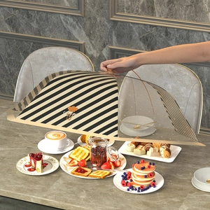 Foldable mesh food cover with wooden handle protecting desserts on a marble table