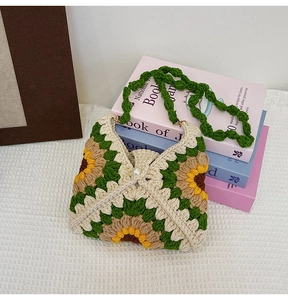 Detail of hand-crocheted sunflower bag showing knit texture and pearl buckle closure