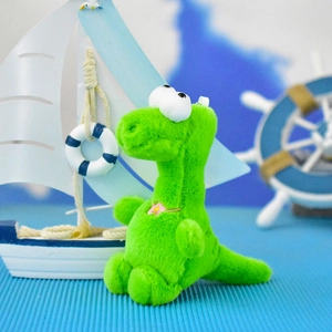 Close-up of a cute green plush dinosaur keychain with a nautical background decor